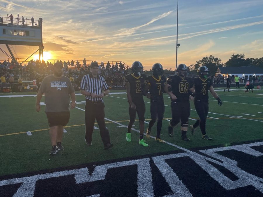 Head Coach Nick Lopez leads his Spartans onto the field for the opening coin toss.